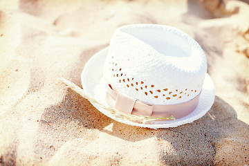 Image showing white straw hat lying in the sand on the beach