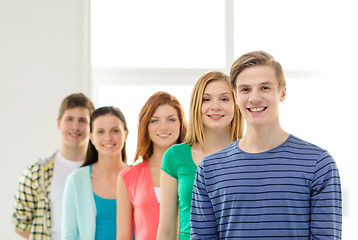 Image showing smiling students with teenage boy in front