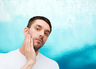 Image showing beautiful calm man touching his face