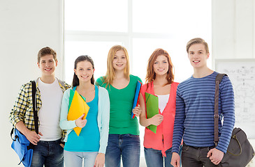 Image showing smiling students with bags and folders at school