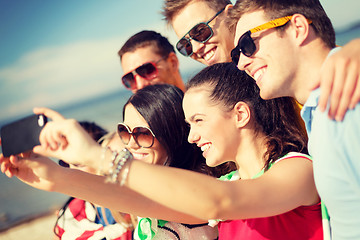 Image showing group of friends taking picture with smartphone
