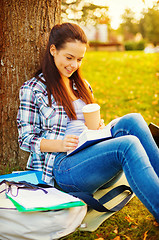 Image showing teenager reading book with take away coffee