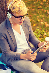 Image showing smiling male student in eyeglasses with tablet pc