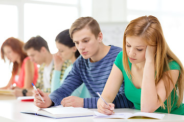 Image showing tired students with textbooks and books at school