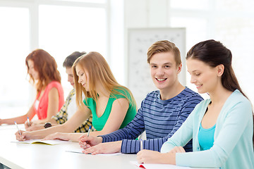 Image showing smiling students with textbooks at school