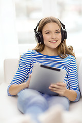 Image showing girl with tablet pc and headphones at home