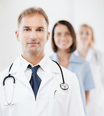 Image showing doctor with stethoscope and colleagues