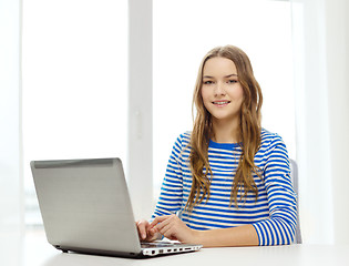 Image showing smiling teenage gitl with laptop computer at home