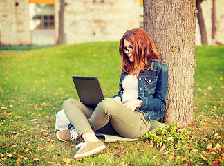 Image showing smiling teenager in eyeglasses with laptop