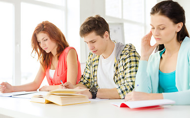 Image showing tired students with textbooks and books at school