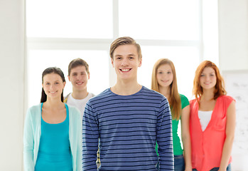 Image showing smiling students with teenage boy in front