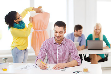 Image showing smiling fashion designers working in office