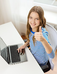 Image showing smiling teenage gitl with laptop computer at home