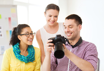 Image showing smiling team with photocamera working in office