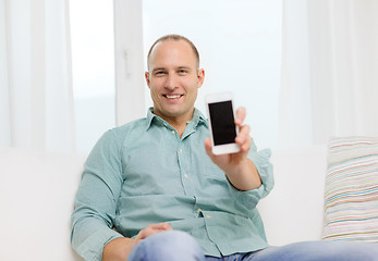 Image showing smiling man with smartphone at home