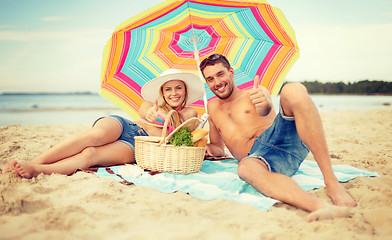 Image showing smiling couple sunbathing on the beach