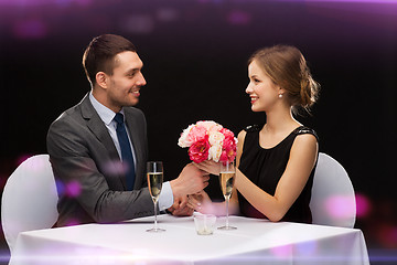 Image showing smiling man giving flower bouquet to woman