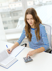 Image showing student girl with book, calculator and notebook