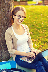 Image showing smiling teenager in eyeglasses with laptop