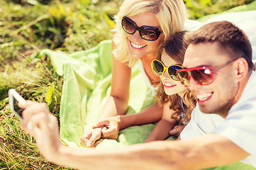 Image showing happy family with camera taking picture