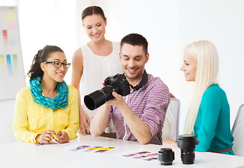 Image showing smiling team with photocamera working in office