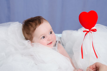 Image showing Girl-baby in the crib give heart