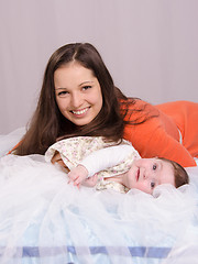 Image showing Mom and baby lying on the bed having fun