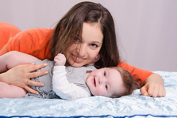 Image showing Mom and seven-month baby lying on couch fun
