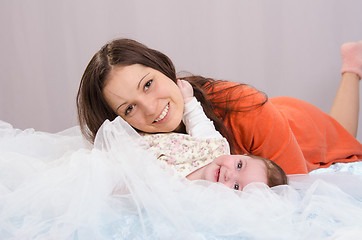 Image showing Mom and daughter having fun six-month lay on bed