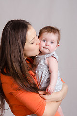 Image showing Young happy mother kissing her daughter