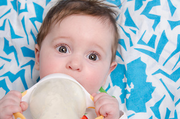 Image showing Six-month girl drinking milk formula from a bottle