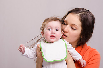 Image showing Six-month baby girl in bib tear your hair mom