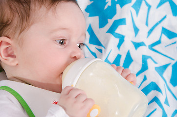 Image showing Baby drinking milk formula from a bottle