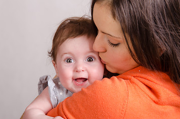 Image showing Mom kisses a six-month daughter