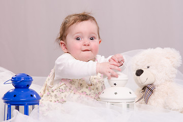 Image showing Six-month baby girl playing with toys on couch