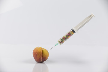 Image showing Peach and syringe with pills