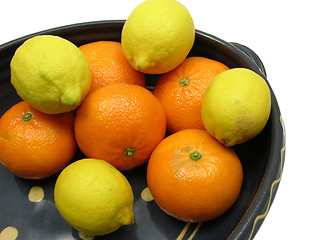 Image showing Ceramic pot with citrons and tangerine on white background