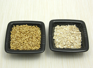 Image showing Bowls of chinaware with oat and porridge on beige placemat