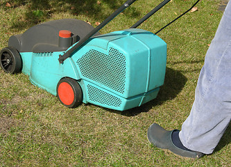 Image showing Cutout man with lawn mower doing his work