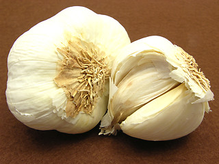 Image showing Two garlic cloves arranged on a brown background