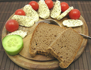 Image showing Sliced mozzarella with little tomatoes, a slice of cucumber and