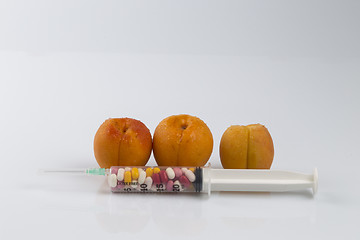 Image showing Peaches and syringe with pills