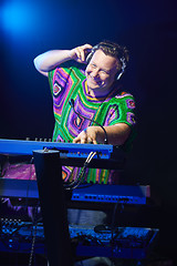 Image showing Happy mid age musician playing on a keyboard