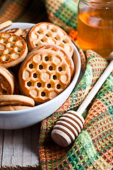 Image showing fresh cookies in a bowl, tablecloth and honey 