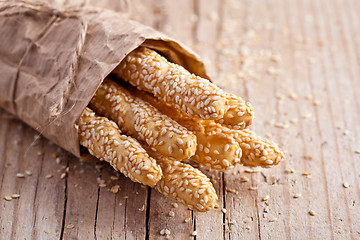 Image showing bread sticks grissini with sesame seeds in craft pack 