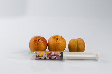 Image showing Peaches and syringe with pills