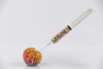 Image showing Peach and syringe with pills