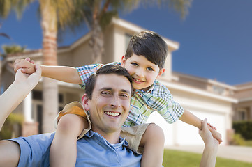 Image showing Mixed Race Father and Son Piggyback in Front of House