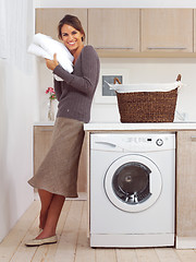 Image showing pretty smiling girl in the laundry room l