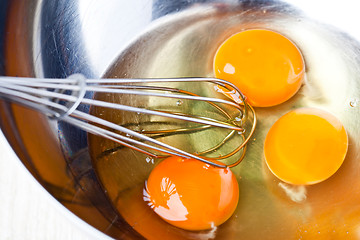 Image showing whisking eggs in metal bowl 